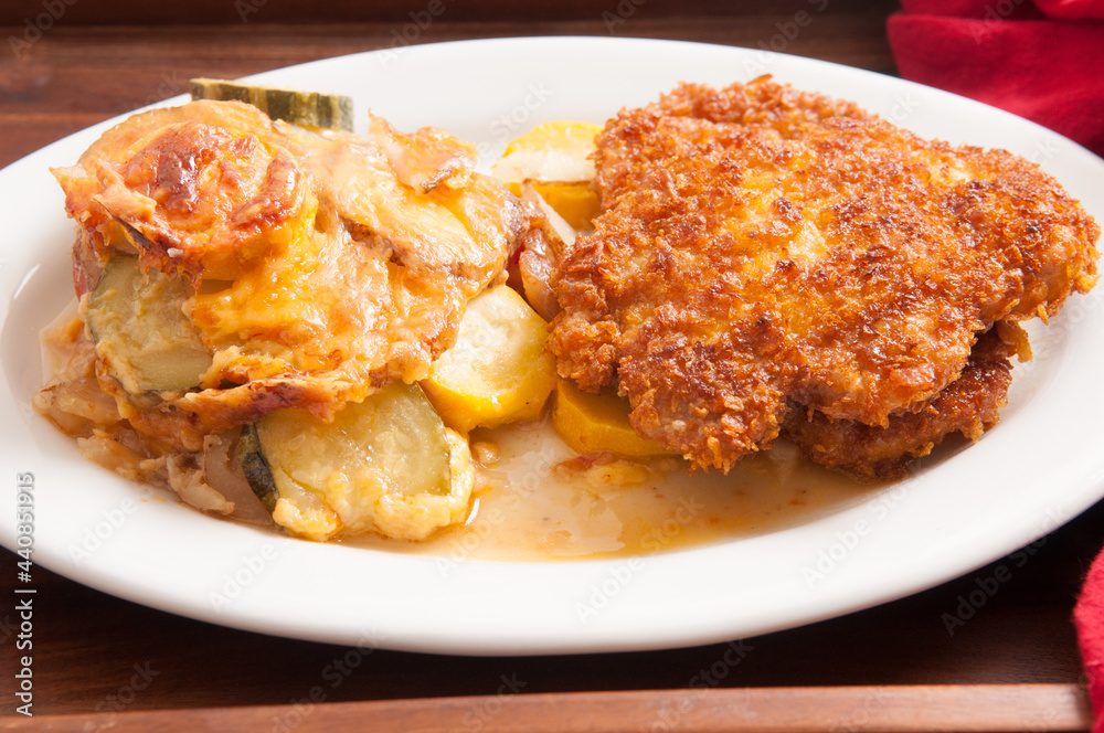 Sticker Close-up shot of cutlet with tomato bake casserole, and zucchini on a white plate