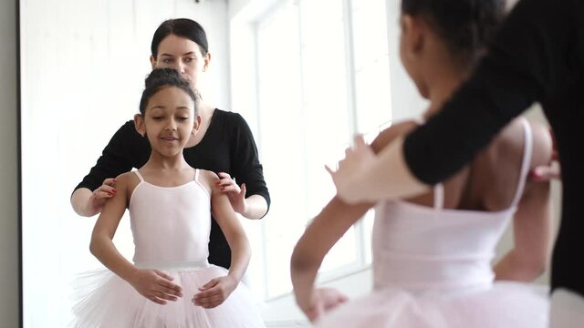 Woman teaching African girl how to dance ballet