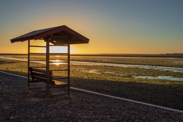 banca a la orilla de un lago al atardecer