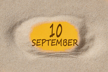 September 10. 10th day of the month, calendar date. Hole in sand. Yellow background is visible through hole. Autumn month, day of the year concept
