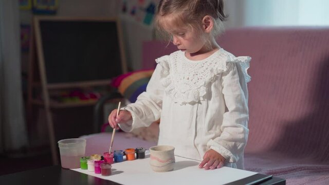 Little Girl Painting Handmade Pot At Home Hobby Leisure Arts Crafts Concept Child Paint Handcraft Clay Figure. High quality 4k footage