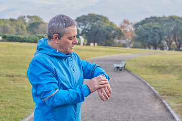 Fototapeta premium Young adult male, wearing, preparing his watch to start running training.