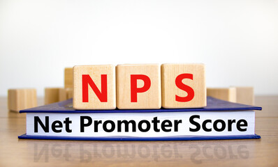NPS net promoter score symbol. Wooden cubes on book with words 'NPS net promoter score'. White background. Business and NPS net promoter score concept. Copy space.