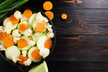 Raw Vegetables in Baking Pan. Slices of zucchini, carrots and cauliflower.Top View with copy space