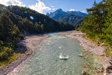 Vibrant shot of the Isar river in Austria on background of mountains