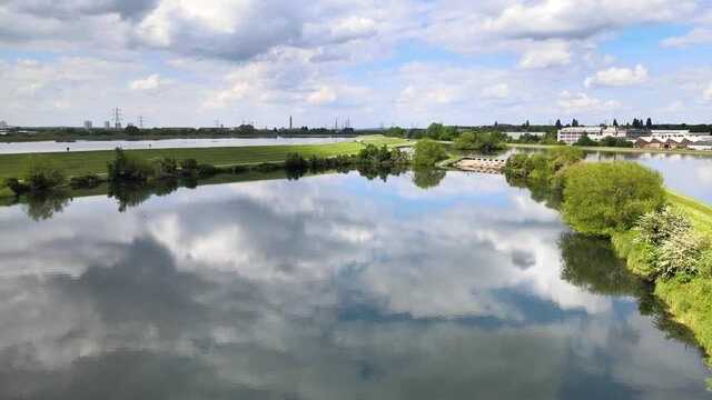 Sunny windless day at Walthamstow Reservoirs. Drone flying above water surface mirroring sky