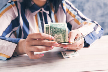 woman counting money in front of the table