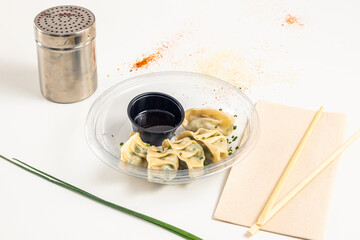 serving of vegetable gyozas with soy sauce inside a plastic container for home delivery