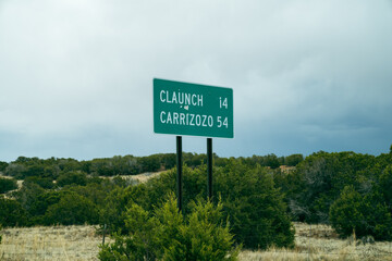 Obraz premium Directional mileage road sign in New Mexico for two small towns - Claunch and Carrizozo