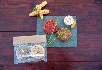 Sous vide cooking concept and low temperature cooking. Vacuum packed ingredients arranged on stained wooden background. Top view. Veggie burgers