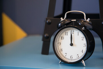 Black alarm clock with time as twelve o, clock