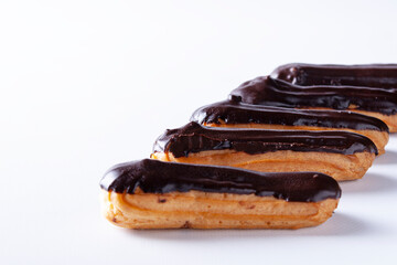 Eclairs filled with chocolate icing on a white background.