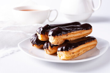 Eclairs with chocolate icing on a white background.