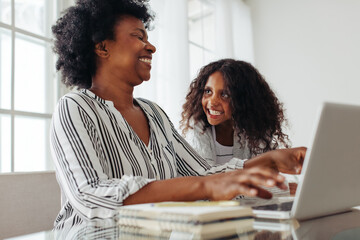 Mother sitting with daughter and working from home