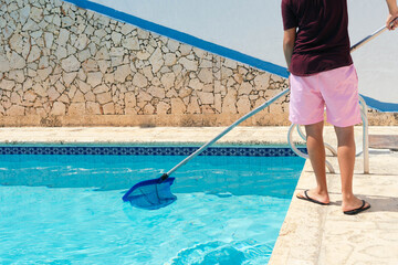 Man cleaning the pool with a net