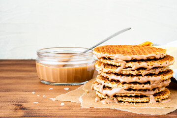 Traditional local authentic Dutch Netherlands sweet fresh homemade tasty stack brown golden waffle melt salted caramel honey syrup for dessert in cafe with hot warm coffee milk tea call Stroopwafel