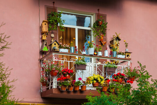 A picturesque balcony of the house, decorated with flowers and various objects