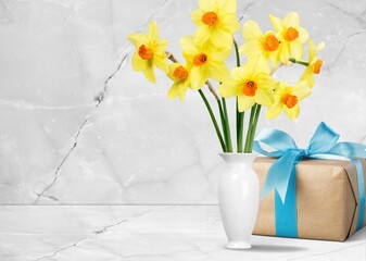 A beautiful bouquet of fresh flowers and gift box on a table.
