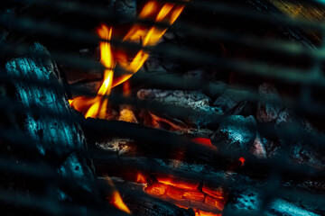Photo of fire that is rising from beneath a grill surface.