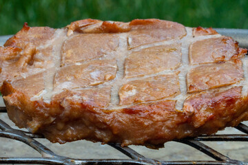 A turkey burger with grill marks while cooking above a fire pit on a sunny day of June 20, 2021....