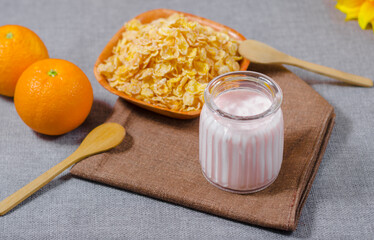 yogurt with natural glutem-free wheat cereal, with fresh orange fruits in a glass cup and a wooden bowl. with copyspace room for text. Greek