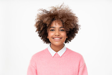 Studio portrait of smiling african teen girl with curly afro hairstyle isolated on gray background