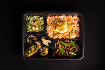 hot roll, shimeji, salmon and sunomono in disposable packaging