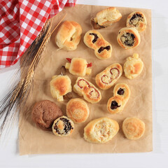 Assorted One Bites Mini Bread or Popular as Roti Unyil Venus on White Plate, White Background. Served for Accompanied Tea. Copy Space for Text