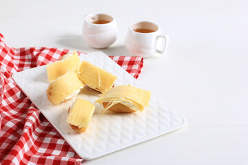One Bites Mini Cheese Bread or Popular as Roti Unyil Venus on White Plate, White Background. Served for Accompanied Tea. Copy Space for Text
