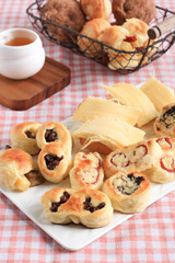 Assorted One Bites Mini Bread or Popular as Roti Unyil Venus on White Plate, White Background....