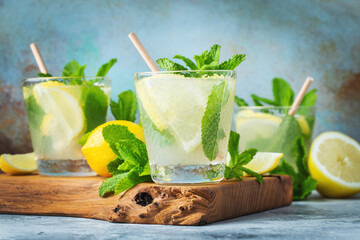 Two glass with lemonade or mojito cocktail with lemon and mint, cold refreshing drink or beverage...