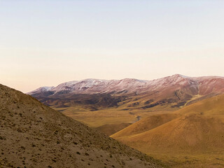 Fototapeta na wymiar dirt road passing through a barren desert, valley between small mountains, yellow mountains