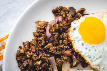 SisigSilog- is a typical Filipino Breakfast meal, consisting usually of sisig (a dish made from parts of a pig's face and belly, and chicken liver) , fried egg and fried rice