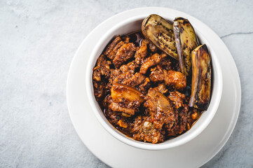 Pork Binagoongan -is a type of pork stew wherein pork slices (usually the belly part), are sautéed in onion, garlic, and tomato, and then cooked with shrimp paste garnished with fried eggplant.