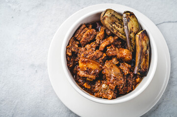 Pork Binagoongan -is a type of pork stew wherein pork slices (usually the belly part), are sautéed in onion, garlic, and tomato, and then cooked with shrimp paste garnished with fried eggplant.