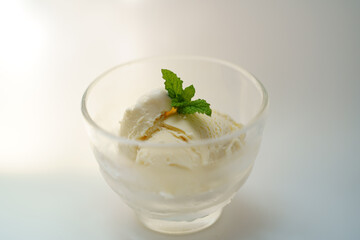 木漏れ日の中のミントの葉が乗ったバニラアイスクリーム　