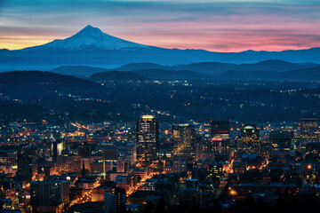 A colorful cityscape sunrise with Mt Hood and the city lights of Portland, Oregon