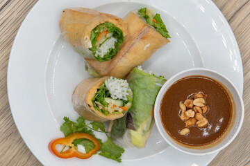 Overhead view of hearty plate of tofu spring rolls cut in halves for a complete meal