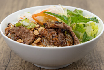 Hearty bowl of vermicelli noodles and seasoned beef with plenty of vegetables for a complete meal