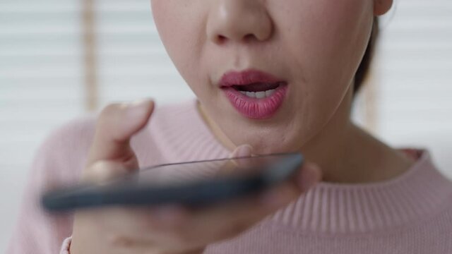 Close-up asia young people teen happy girl sit relax call use smart phone talk chat send text to 5G wifi mic VoIP deep tech ai bot app at home. Enjoy vocal order to help chatbot iot on social media.