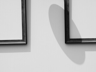 Wooden frame on the white wall with the shadow of the lamp