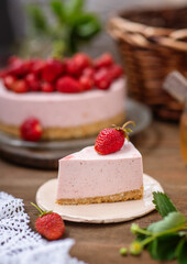 A piece of cheesecake lying on a plate on the background of a whole cake