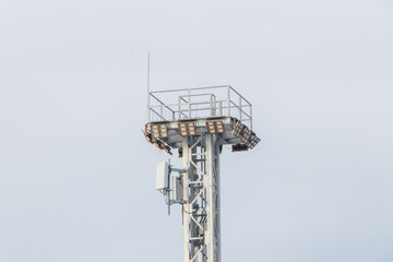 Spotlight pole above have CCTV, phone signal, internet signal in the container yard in the port area the sky background