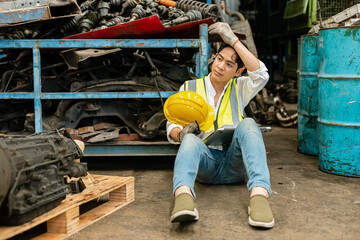 Asian engineering man worker wear uniform holding hardhat sitting tiredness and strain from work....