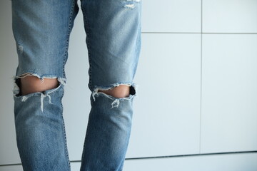 close-up of a man in torn jeans. Blue, old, fashionable, shabby. On a white background. Italian fashion.