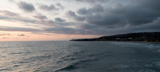 Obraz premium Looking at La Jolla hills from Crystal Pier during stormy sunset,