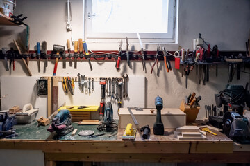 Board with tools. The repair tools are hanging on the wall. Old appliances in the basement.