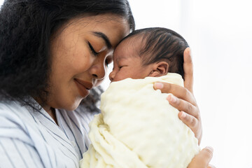 Closeup of happy mother carrying and kissing her newborn baby - Powered by Adobe