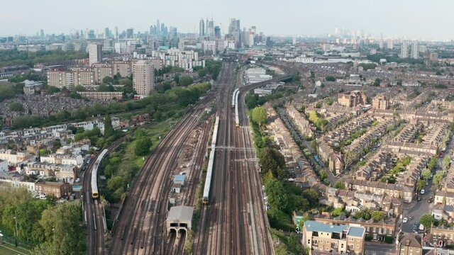 Stationary drone shot of busy British rail train tracks towards London city centre