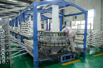 A packaging plant of woven bag workshop machinery is running, workers in the busy work.
